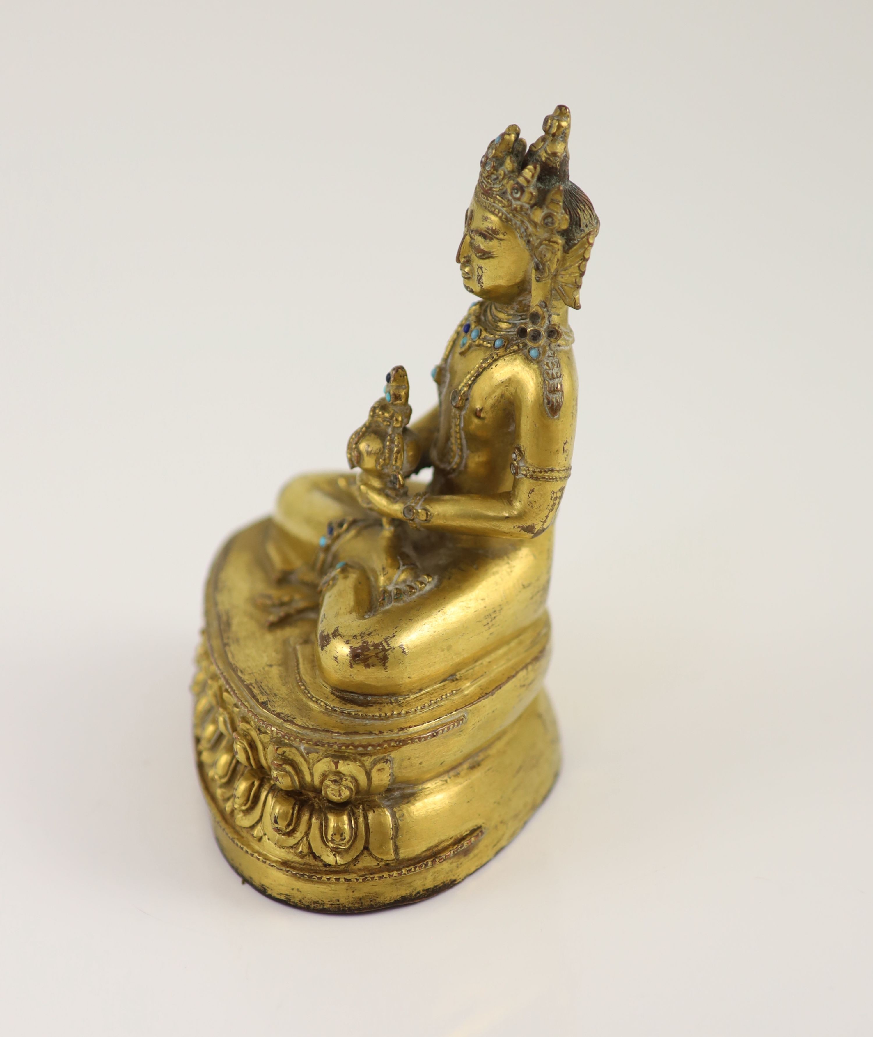 A Tibetan gilt copper alloy seated figure of Amitayus, probably 15th/16th century, 15cm high